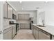 Modern kitchen with gray cabinets, stainless steel appliances, and a large island at 1279 Kazaz Ct, Zephyrhills, FL 33540