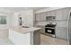 Modern kitchen with gray shaker cabinets, stainless steel appliances, and quartz countertops at 1279 Kazaz Ct, Zephyrhills, FL 33540
