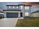 Two story home with grey garage door and landscaping at 1244 Kazaz Ct, Zephyrhills, FL 33540