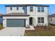 Two-story house with a two-car garage and landscaped front yard at 1244 Kazaz Ct, Zephyrhills, FL 33540