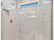 Bright white tiled shower with glass enclosure and built-in seat at 1244 Kazaz Ct, Zephyrhills, FL 33540