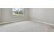 Spacious bedroom with neutral carpeting and a large window at 37886 Clinch Cir, Zephyrhills, FL 33540