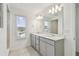 Bathroom features double vanity, large mirror, and tile flooring at 1209 Kistna Dr, Zephyrhills, FL 33540