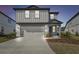 Two-story home with attached garage and landscaping at 1209 Kistna Dr, Zephyrhills, FL 33540