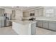 Modern kitchen with grey cabinets, quartz countertops, and stainless steel appliances at 1209 Kistna Dr, Zephyrhills, FL 33540