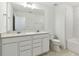 Double sink bathroom with white cabinets and tile at 1185 Kistna Dr, Zephyrhills, FL 33540