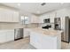 Modern kitchen with white cabinets, island, and stainless steel appliances at 1185 Kistna Dr, Zephyrhills, FL 33540