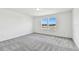 Spacious bedroom with gray carpeting and large windows at 1174 Kistna Dr, Zephyrhills, FL 33540