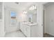 Double vanity bathroom with white cabinets and a large mirror at 1201 Kistna Dr, Zephyrhills, FL 33540