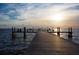 Wooden pier extending over calm water, people relaxing and enjoying the sunset at 3226 Mangrove Point Dr, Ruskin, FL 33570