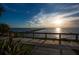 Scenic waterfront view with a wooden walkway and sunset in the background at 3226 Mangrove Point Dr, Ruskin, FL 33570