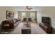 Virtually staged living room featuring a brown leather sofa, two armchairs, and a large TV at 11612 Mansfield Point Dr, Riverview, FL 33569