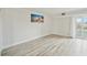 Bedroom with hardwood floors, balcony access, and artwork at 851 Bayway Blvd # 104, Clearwater Beach, FL 33767