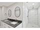 Elegant bathroom with double vanity, dark countertop, and large walk-in shower at 8320 Boxwood Dr, Tampa, FL 33615