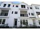 Modern three-story townhome with white siding and black windows at 7404 Newham Ln, Sarasota, FL 34240