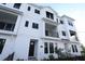 Modern three-story townhome with white siding and black windows at 7404 Newham Ln, Sarasota, FL 34240