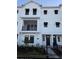 Three-story townhome with modern facade, dark gray door, and small front yard at 7412 Newham Ln, Sarasota, FL 34240