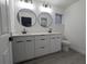 Contemporary bathroom with double vanity, round mirrors, and gray flooring at 14018 Barlington St, Spring Hill, FL 34609