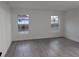 Bright bedroom with two windows, gray flooring, and white walls at 14018 Barlington St, Spring Hill, FL 34609