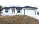 Newly constructed home with a white exterior, dark gray accents, and a two-car garage at 14018 Barlington St, Spring Hill, FL 34609