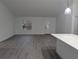 Bright and spacious living room with gray vinyl flooring and a view to the kitchen at 14018 Barlington St, Spring Hill, FL 34609