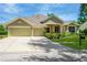 Tan three-car garage house with manicured lawn at 806 Red Ash Ct, Seffner, FL 33584