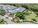 An aerial view of a home with a lush front yard, palm trees, and a driveway at 905 Seagrape Dr, Ruskin, FL 33570