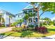 Two-story light blue house with a welcoming front porch, landscaping, and palm trees at 905 Seagrape Dr, Ruskin, FL 33570