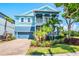 Beautiful two-story home with a blue exterior, columns, landscaping, and a driveway at 905 Seagrape Dr, Ruskin, FL 33570