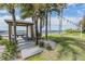 Peaceful outdoor area with a gazebo, tropical trees, and string lights, providing a relaxing space with ocean views at 905 Seagrape Dr, Ruskin, FL 33570