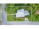 Aerial view of a home featuring a metal roof, fenced yard, and mature landscaping at 14006 5Th St, Dade City, FL 33525