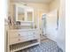 Bathroom featuring a double sink vanity, decorative tile flooring, and a door leading to an adjacent bathroom at 14006 5Th St, Dade City, FL 33525