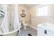 Charming bathroom with a clawfoot tub, patterned tile flooring, and a decorative nautical theme at 14006 5Th St, Dade City, FL 33525