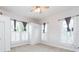 Bright bedroom featuring a ceiling fan, closet with bi-fold doors and two windows with shutters at 14006 5Th St, Dade City, FL 33525