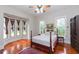 Charming bedroom with bay window, wood floors, ceiling fan, and a four-poster bed at 14006 5Th St, Dade City, FL 33525