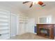 Bedroom featuring carpet, ceiling fan, built in shelving and a charming brick fireplace at 14006 5Th St, Dade City, FL 33525