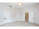 Bright bedroom featuring a ceiling fan and two doors leading to other parts of the house at 14006 5Th St, Dade City, FL 33525