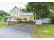 Two story home with shade and a rock driveway with a white picket fence at 14006 5Th St, Dade City, FL 33525