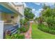 Charming front yard featuring a brick path, garden, lush lawn and swing on the porch of the yellow house at 14006 5Th St, Dade City, FL 33525