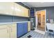 Laundry room features blue and yellow cabinets, patterned flooring, and a view into the bathroom at 14006 5Th St, Dade City, FL 33525