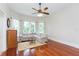 Inviting living room featuring wood floors, large windows, a comfortable sofa, and a ceiling fan at 14006 5Th St, Dade City, FL 33525