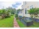 Side yard featuring a brick path, garden, lush lawn, and a view of the side of the yellow home at 14006 5Th St, Dade City, FL 33525