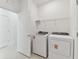 Spacious laundry room with white appliances and tile floors and access to the hallway at 20783 Balsam Hill Rd, Land O Lakes, FL 34638