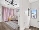 Bedroom with pink curtains, crib, and plenty of natural light at 2506 N Highland Ave, Tampa, FL 33602