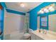 Simple bathroom with a shower/tub combo and bright blue walls at 4502 Hill Dr, Valrico, FL 33596