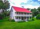 Two-story home, red metal roof, large porch, and spacious yard at 4502 Hill Dr, Valrico, FL 33596