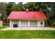 Three-car garage with red metal roof and ample parking space at 4502 Hill Dr, Valrico, FL 33596