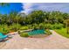 Freeform swimming pool with a sandy beach entry and waterfall feature at 4502 Hill Dr, Valrico, FL 33596