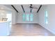 Open living room with hardwood floors, wood beams, and view to kitchen at 1501 63Rd W St, Bradenton, FL 34209