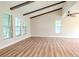 Bright living room featuring hardwood floors, vaulted ceilings with wood beams, and multiple windows at 1501 63Rd W St, Bradenton, FL 34209